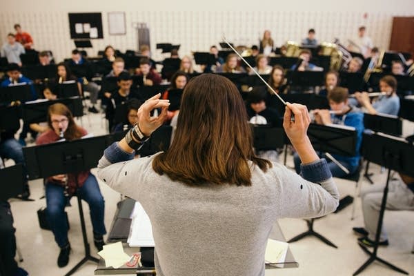 Poster Nora Tycast conducts her band class.