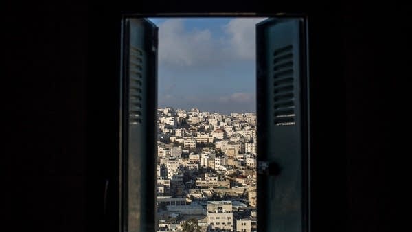 A Palestinian neighborhood is seen from the window of a building inside an Israeli settlement in Hebron in January 2017.