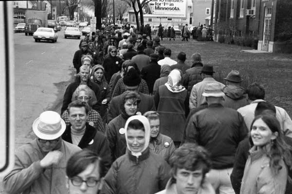 People stand outside in a picket line.