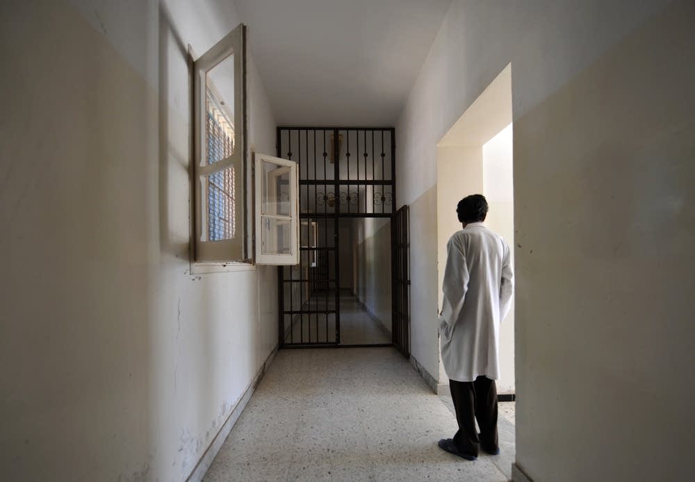 A metal-barred doors stands open in a hall of the
