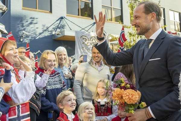 A prince greets a crowd in Norwegian clothing