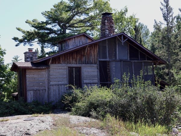 a grey and brown house surrounded by trees