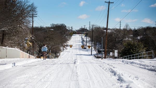 A person walks on an empty street in East Austin, Texas, in February 2021 during Winter Storm Uri. Since then, a lot of Texas' energy infrastructure has been winterized. 