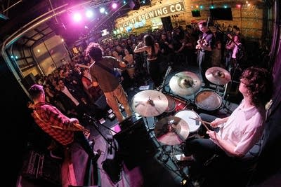 Five musicians performing onstage