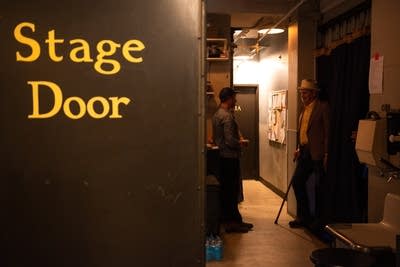 Two people talking backstage at a theater