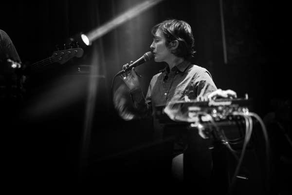 A musician sings onstage in a music club