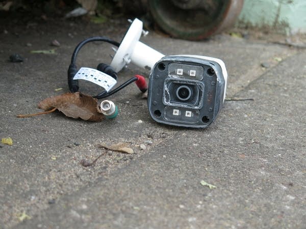 a security camera lies on pavement