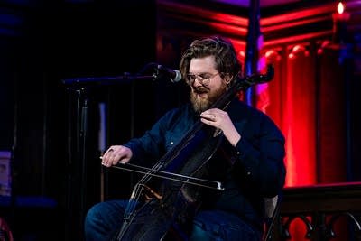 Man playing the cello inside church
