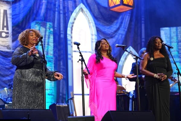Three woman perform together onstage