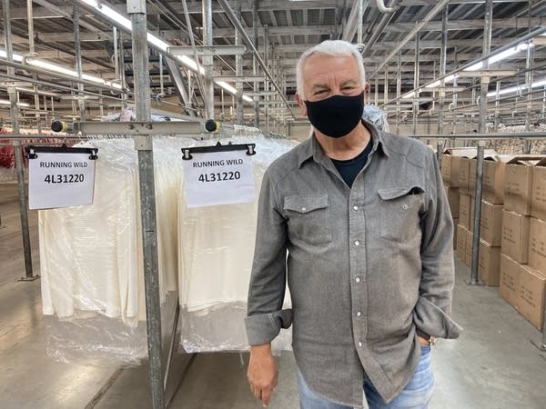 Lonnie Kane stands in front of garments hanging on a rack in the Karen Kane facility in Los Angeles.