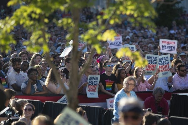 A crowd of people hold signs