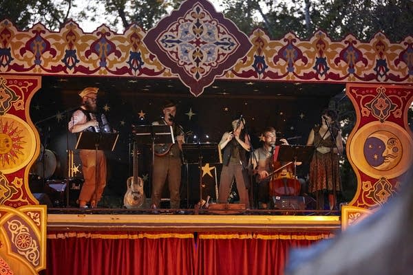 Five musicians performing onstage