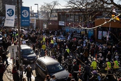 People ride past a memorial