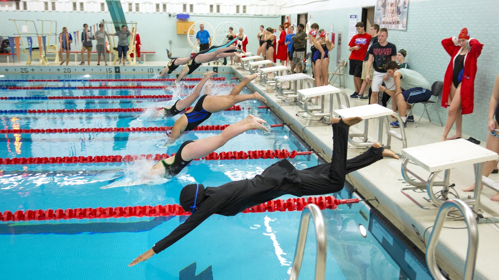 Nimo Gohe, right, dives in for the 50-meter freestyle event.