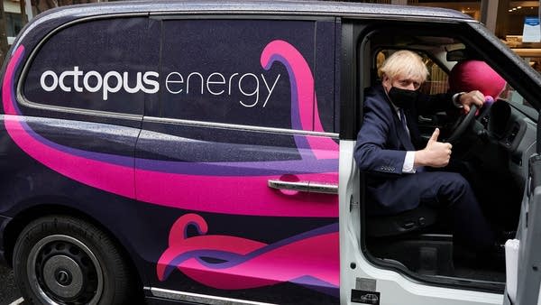 Prime Minister Boris Johnson poses in an electric taxi. His government has accelerated its plan to move the country to electric transportation.