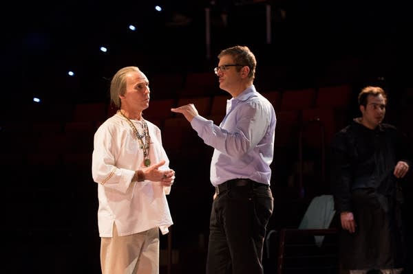 Two people speak on a stage.