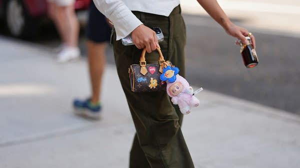 An attendee at New York Fashion Week in September sports both a Louis Vuitton bag and an attached Labubu.