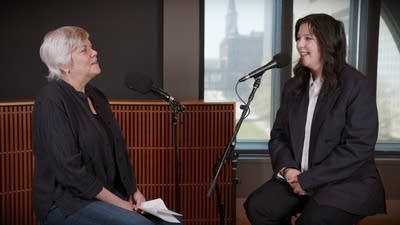 Two women have a conversation in a recording studio