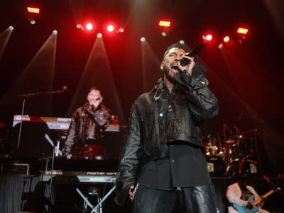 Miguel sings into a microphone.