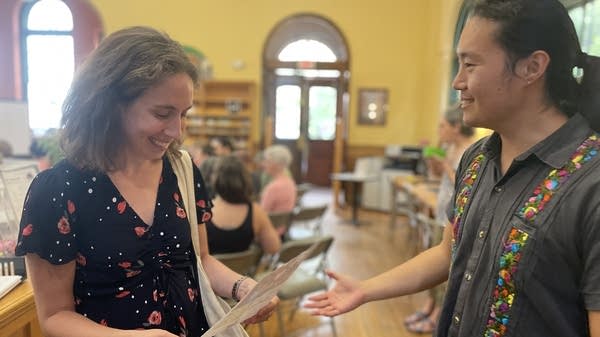 Alex Zhu (right) talks with Kara Hunersen about the Community Guaranteed Income Club he started last year in Baltimore.