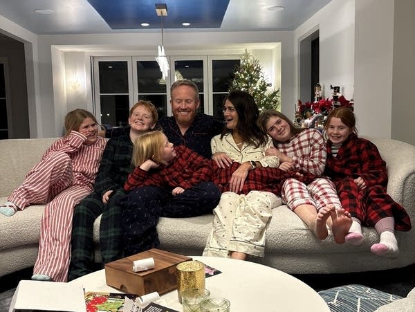A family on a couch in Christmas pajamas
