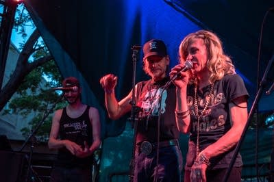 A rock band performing on an outdoor stage