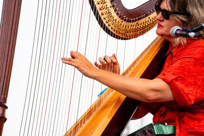 Mary Lattimore performing on an outdoor stage.
