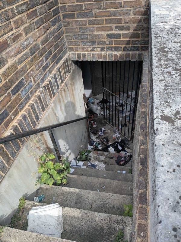 A basement entrance with ashes and debris following a fire.