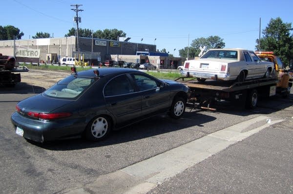 Police say trucks like this one were snatching cars off the street and selling them for scrap at Metro Metals, a salvage yard seen here in the background. No one at the company has yet been charged in the alleged auto theft scheme. MPR Photo/Tim Nelson