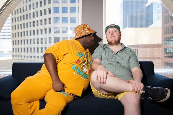 Two people pose on a couch