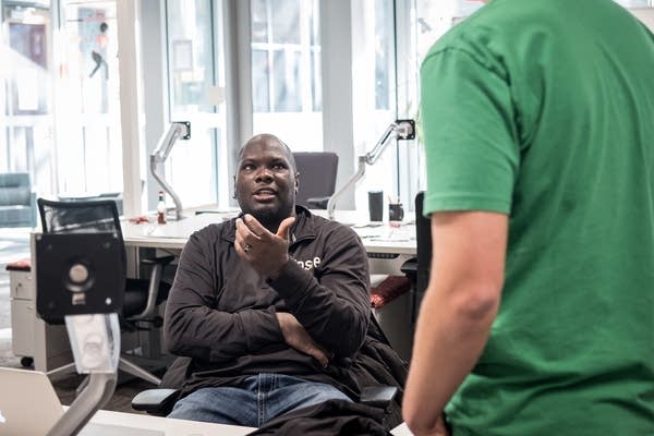 Clarence Bethea, CEO of Upsie, speaks to a colleague in the office in Mpls.