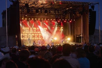 charley crockett and his band performing on an outdoor stage at night