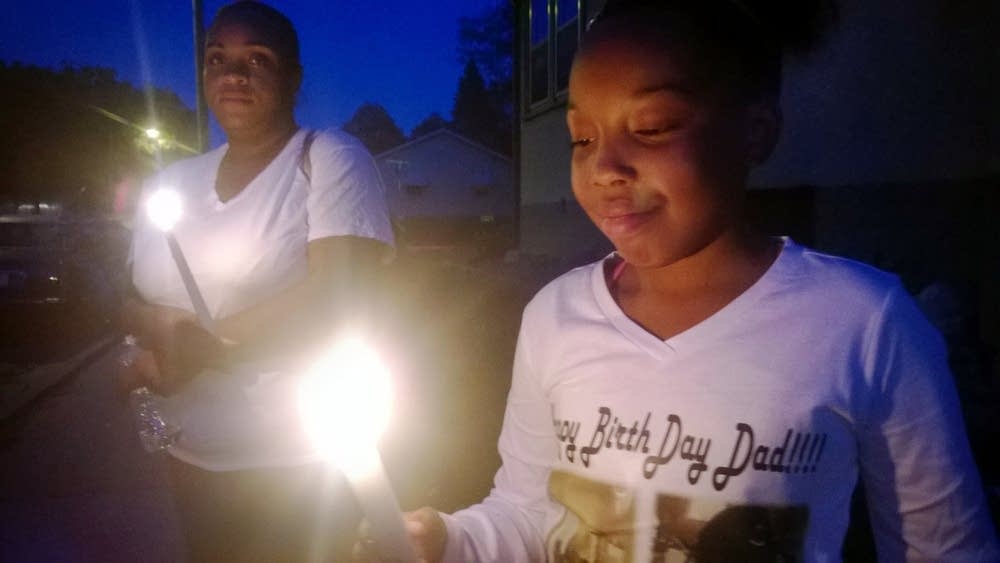 Angel Gaddy lights a candle to honor her father.