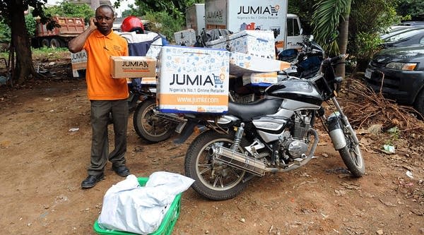 A Jumia scooterman tries to speak to clients to be delivered with product at the Ikeja warehouse of the company in Lagos on June 12, 2013.