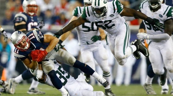 Wide receiver Julian Edelman #11 of the New England Patriots makes a catch in front of inside linebacker David Harris #52 of the New York Jets in the second quarter at Gillette Stadium on September 12, 2013 in Foxboro, Massachusetts.