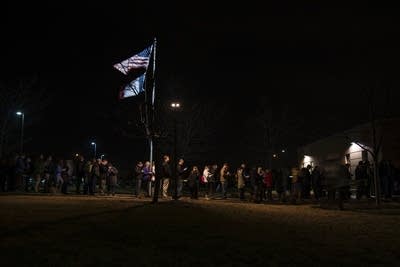 Caucus-goers line up outside an elementary school.