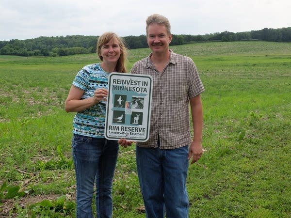 Rob and Loreli Westby stand with a sign.