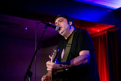 A musician performing onstage in a music venue