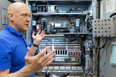 A man showing the inside of traffic signal cabinet