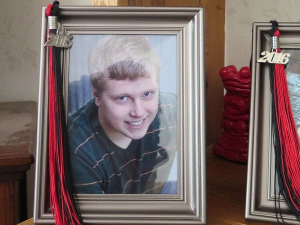 A red and black graduation tassel on a framed photograph.