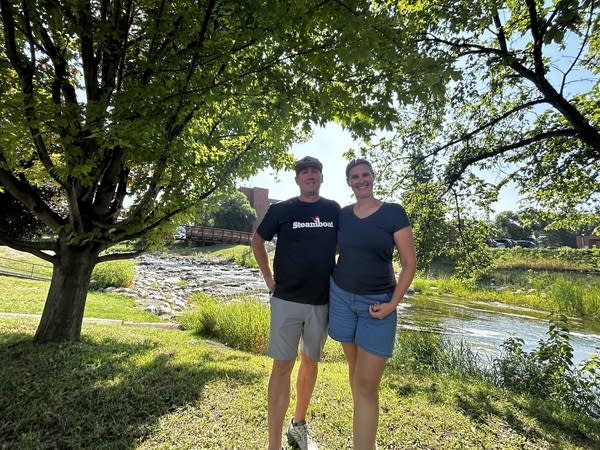 Two people wearing t shirts and shorts pose for outside photo