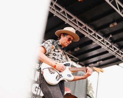 Man wearing guitar on stage