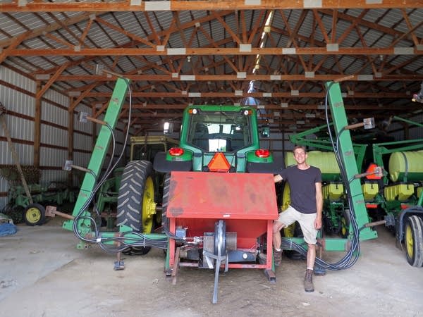 Scott Haase stands with a cover crop planter at his family’s farm.