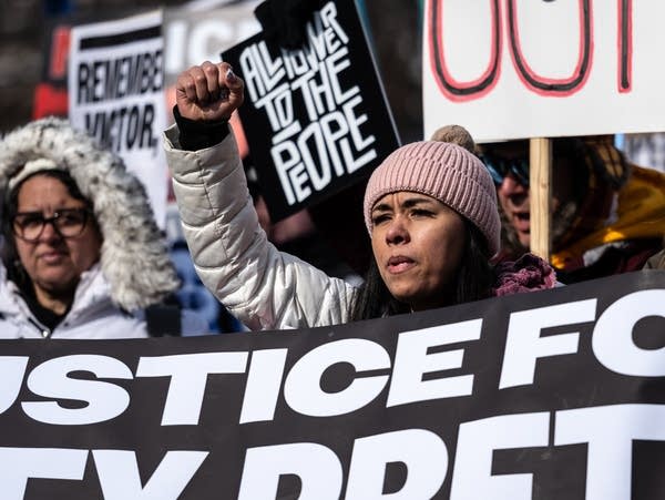 A protester cries and raises their fist during a march