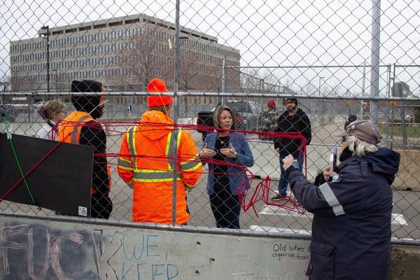 People stand by a fence and talk