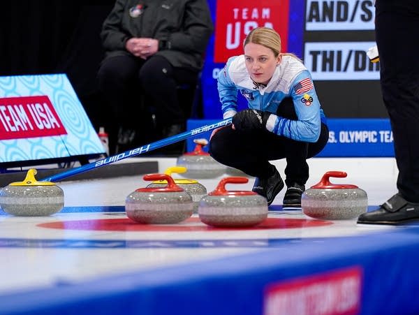 A curler sizes up a throw during a competition