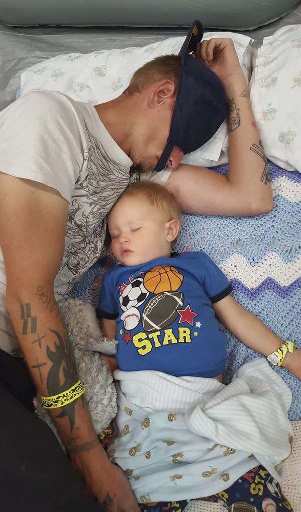 Casey Huffman sleeps next to his 17 month-old son at a shelter.