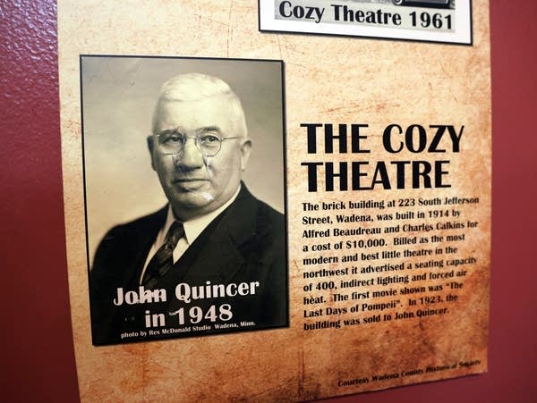 a black and white photo of a man hangs on a wall 