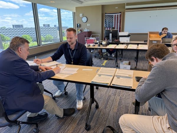 Three people sitting a table in an office