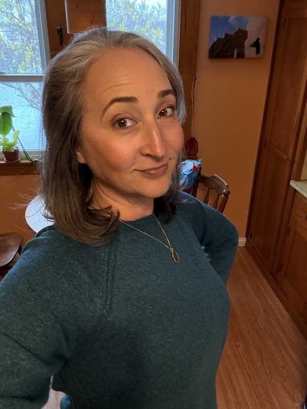 A woman takes a selfie in her home.